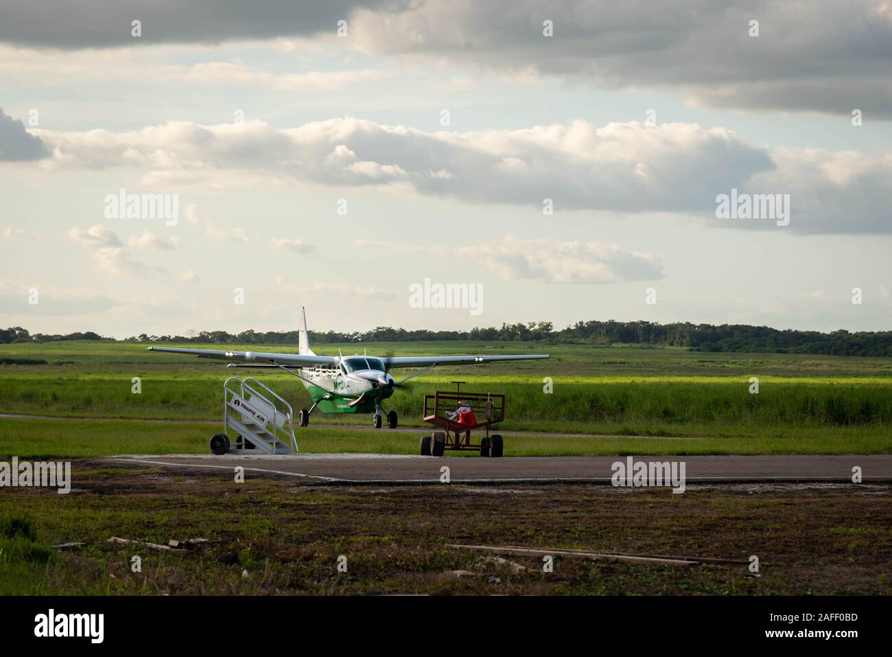 Orange Walk, Belize - November, 16, 2019. Small passenger Maya Island Air aircraft landing on the small asphalted airstrip in the middle of the sugar Stock Photo