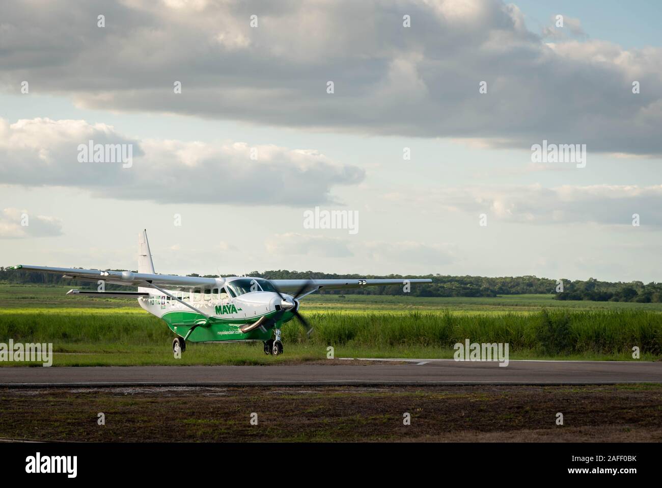 Orange Walk, Belize - November, 16, 2019. Small passenger Maya Island Air aircraft landing on the small asphalted airstrip in the middle of the sugar Stock Photo