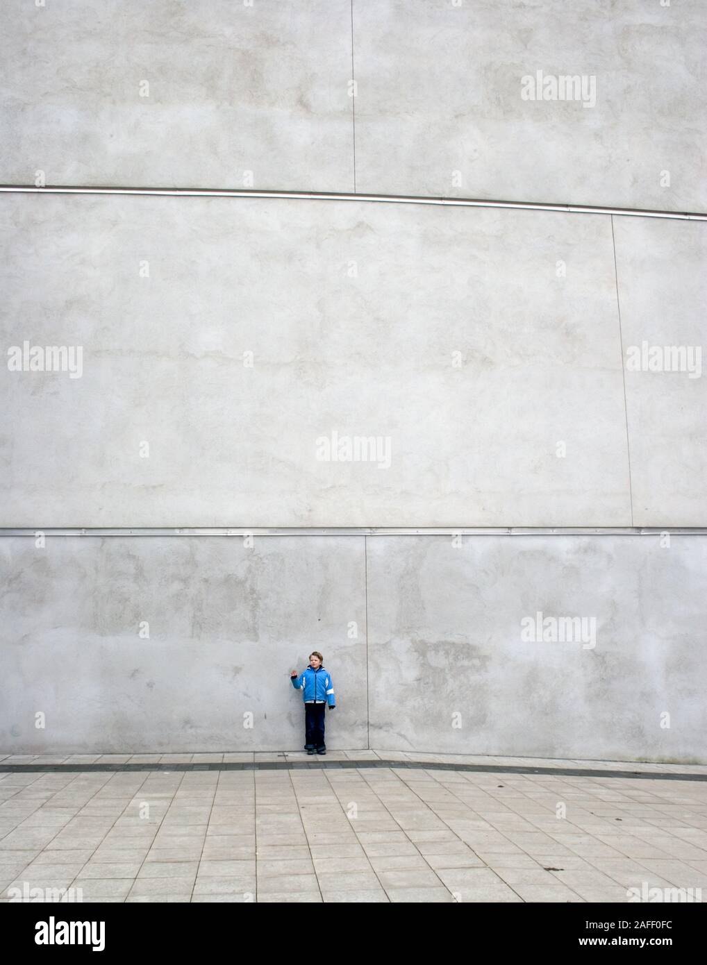 Little lonely man and a big wall Stock Photo