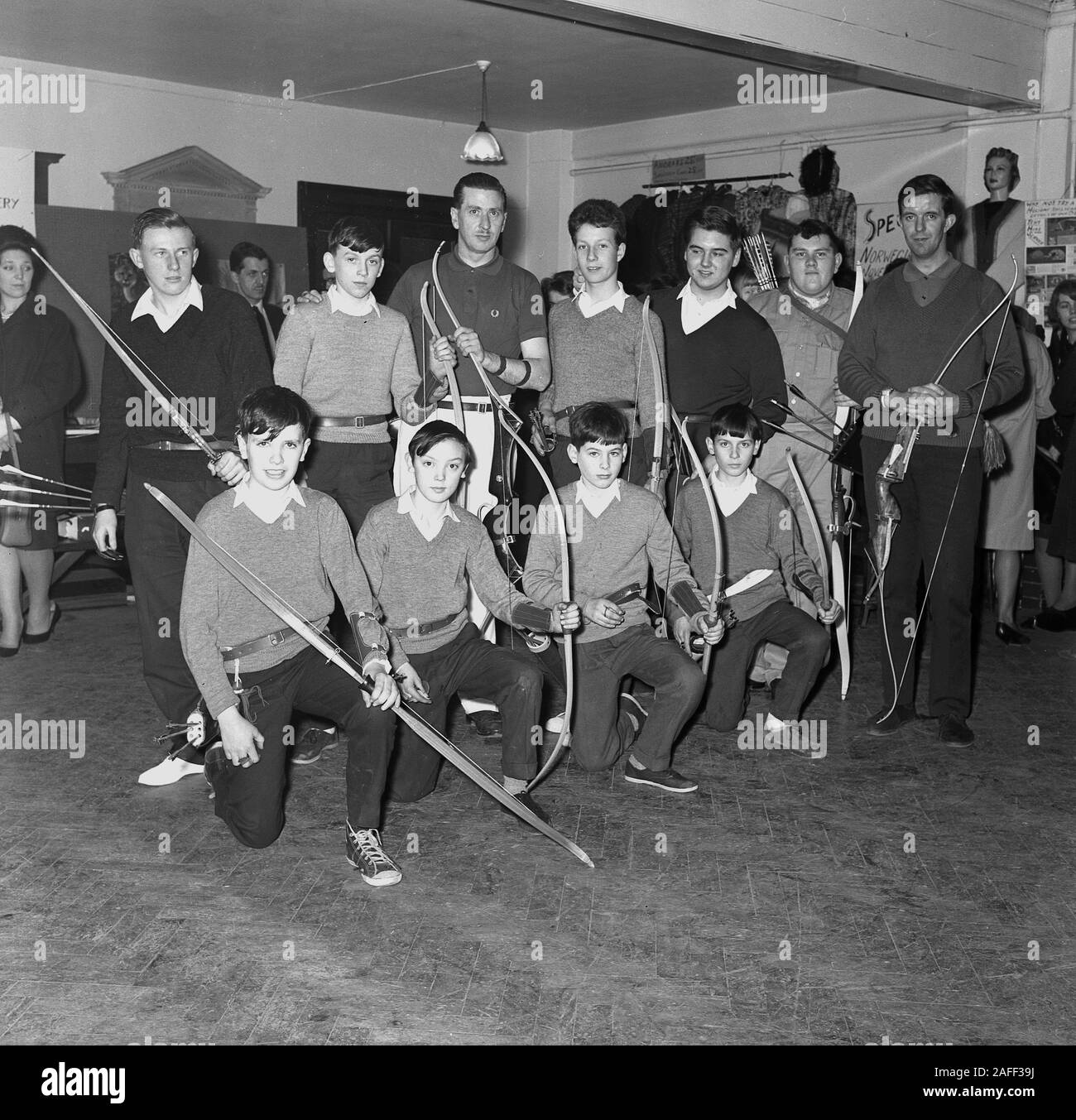 1960s historical, inside a room, young members of an archery club gathered with their bows for a group photo, England, UK. Stock Photo