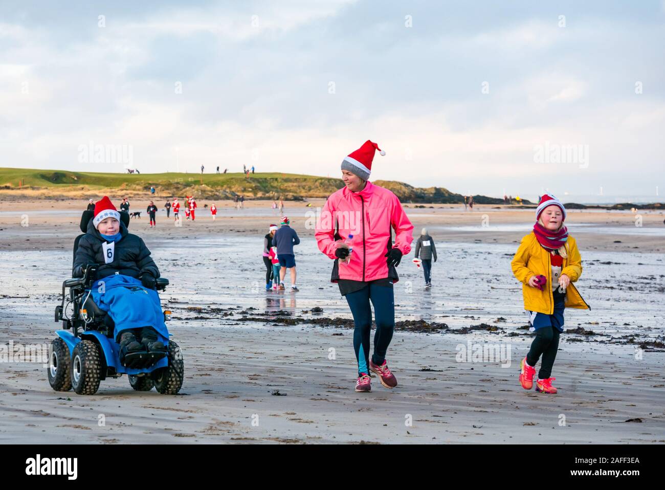 Mother with children with disabled boy in beach wheelchair in Santa run, North Berwick, East Lothian, Scotland, UK Stock Photo