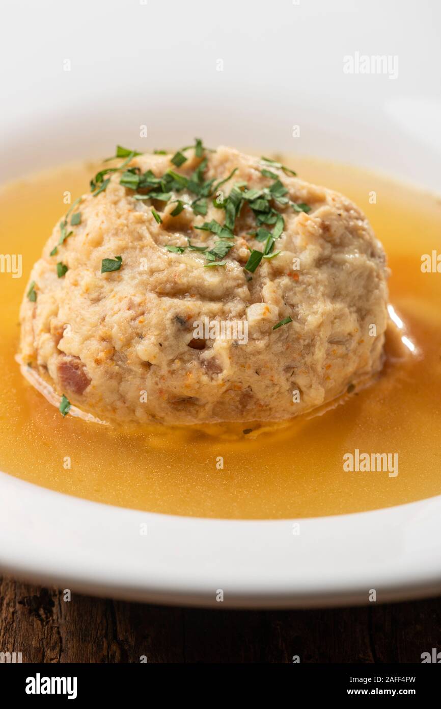 single speckknoedel in soup on wood Stock Photo