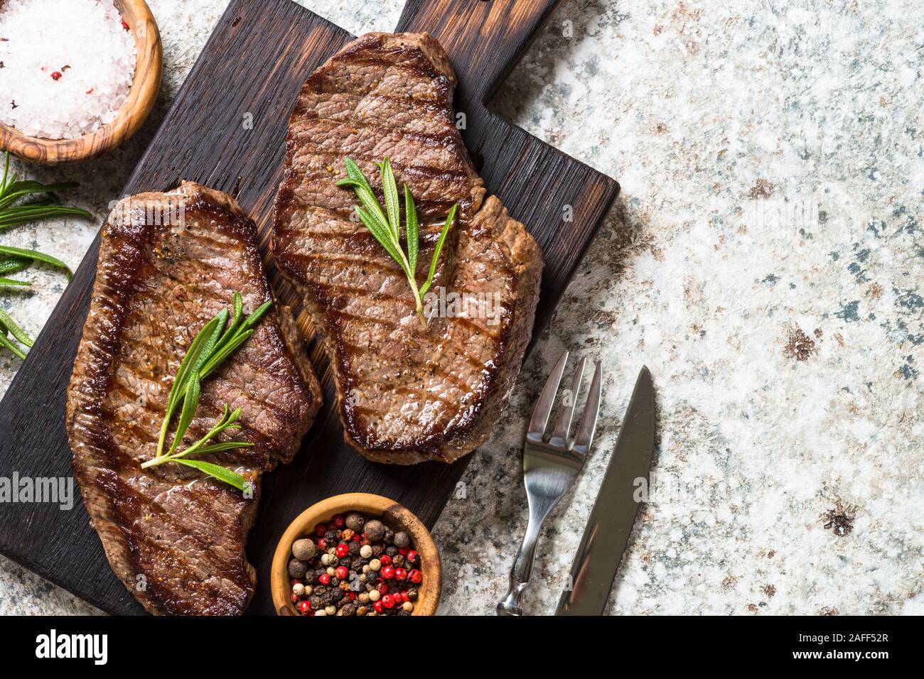 Grilled beef steak on wooden cutting board. Stock Photo