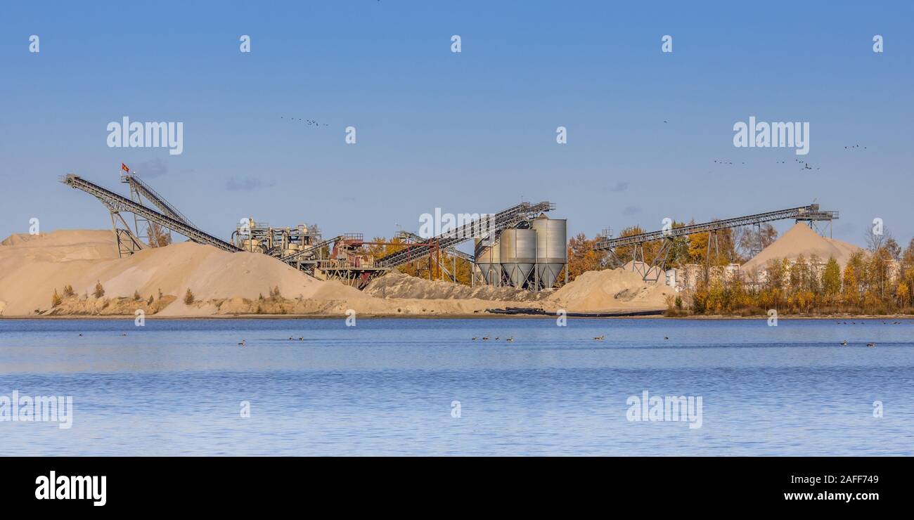 Sand mining at flooded borrow pit or excavation lake in Drenthe Netherlands. Sand is becoming an increasingly scarce building material and sand is get Stock Photo
