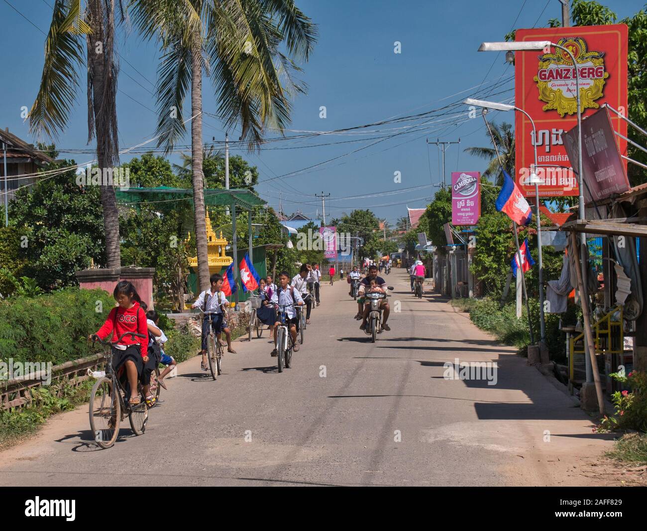 School children on their way home from school at lunchtime on a sunny day - taken on Silk Island / Koh Dach, Phnom Penh, Cambodia Stock Photo