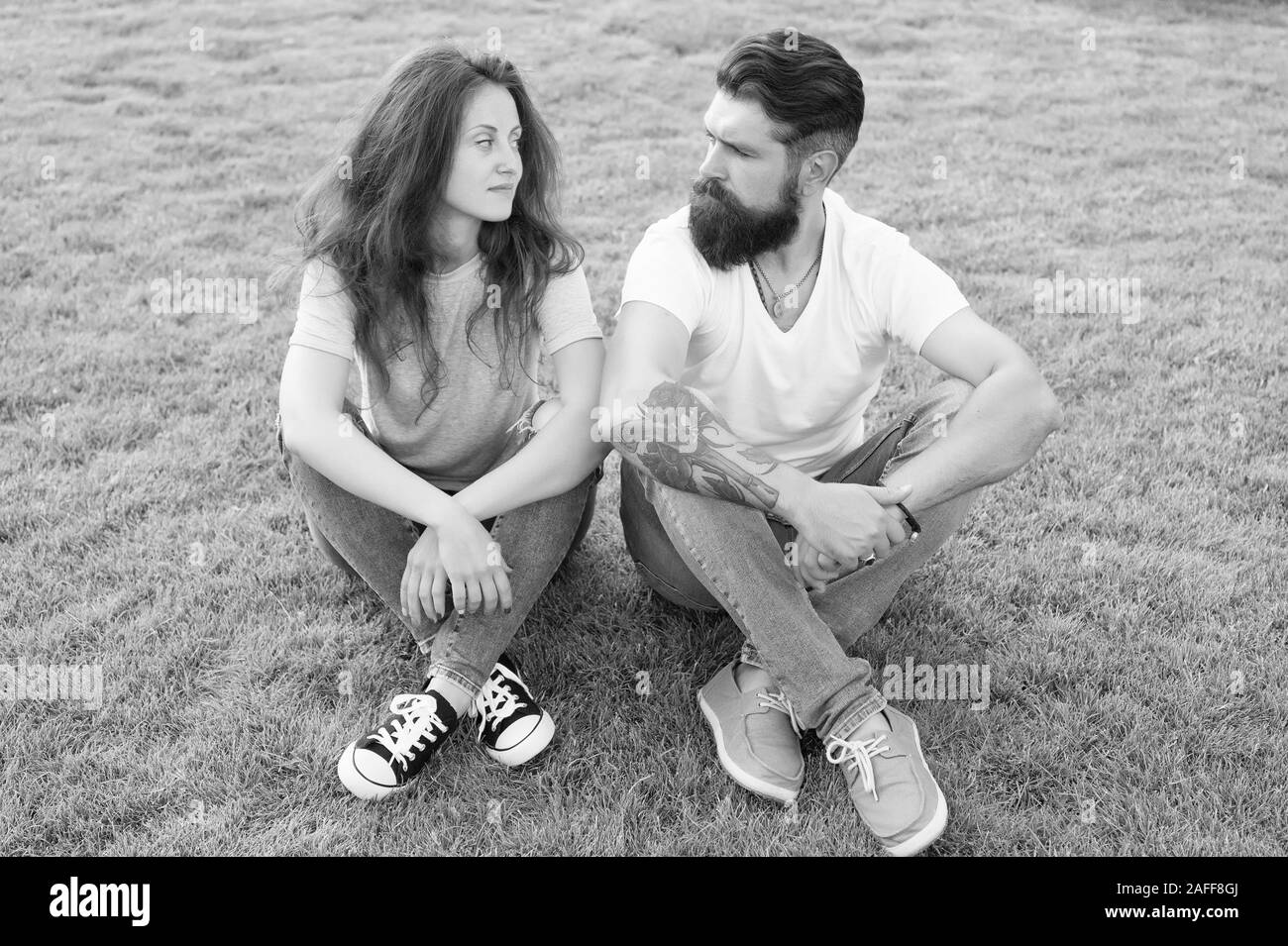 Couple in love relaxing on green lawn. Playful girlfriend and boyfriend dating. Couple relations goals. Couple spend time in nature. Lovely couple outdoors. Soulmates closest people. Simple happiness. Stock Photo