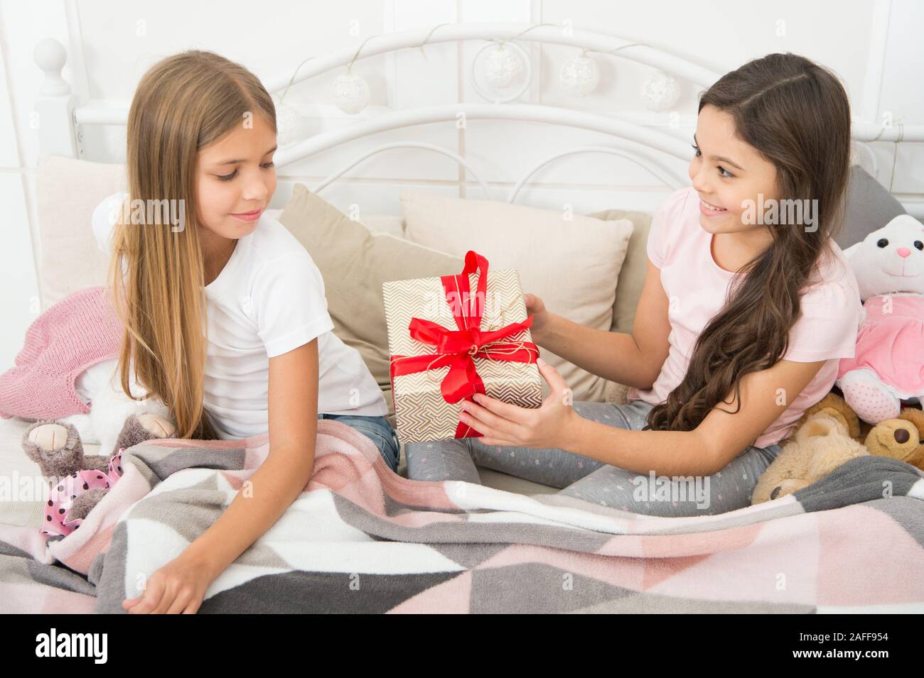 Giving tuesday. Small child giving present to sister. Little girl enjoy ...