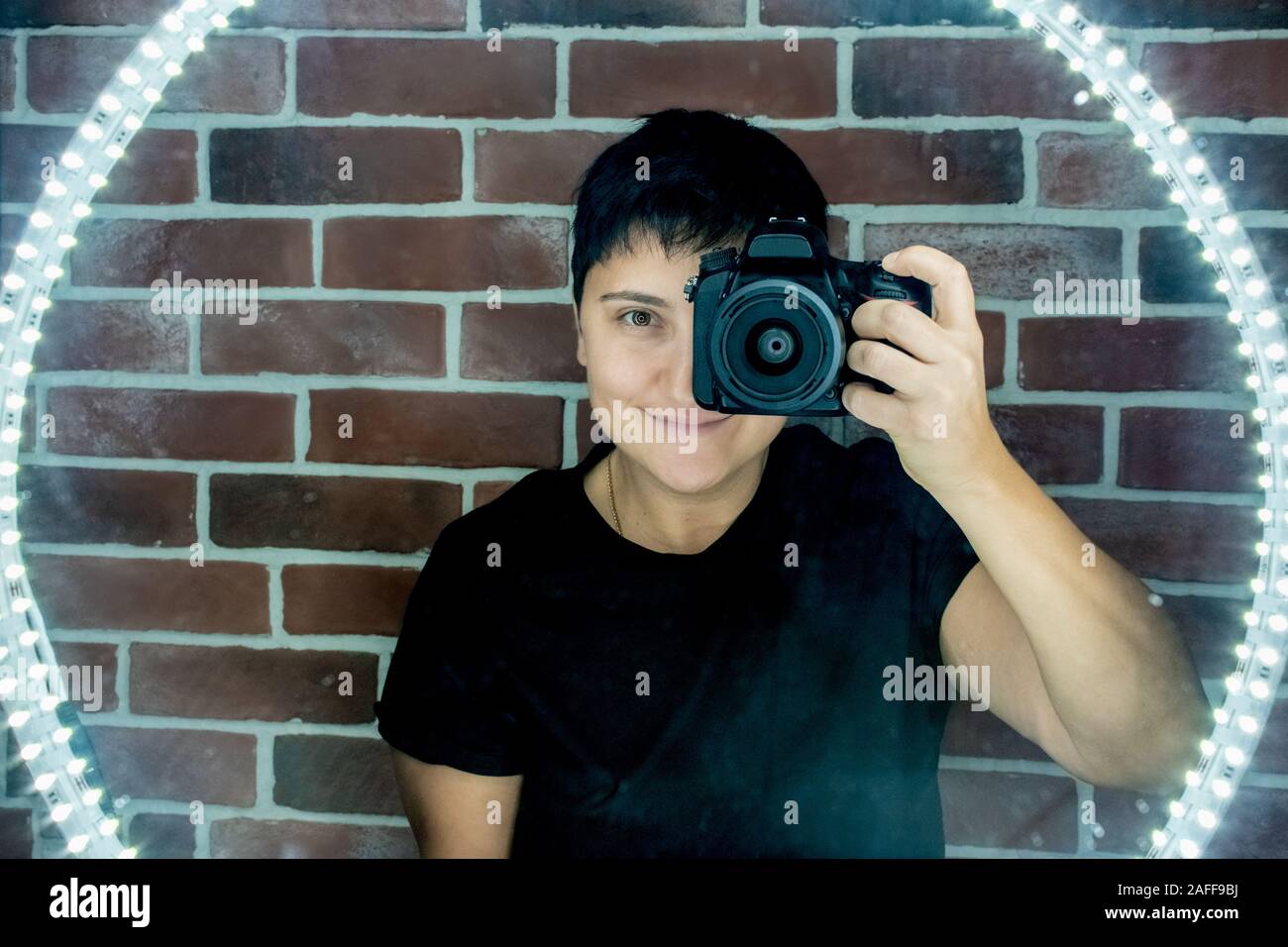 club photographer takes selfie in mirror reflection led lights Stock Photo