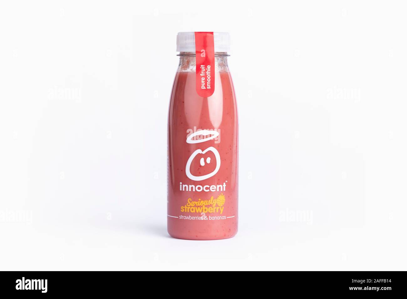 A bottle of Innocent Seriously Strawberry smoothie drink shot on a yellow background. Stock Photo