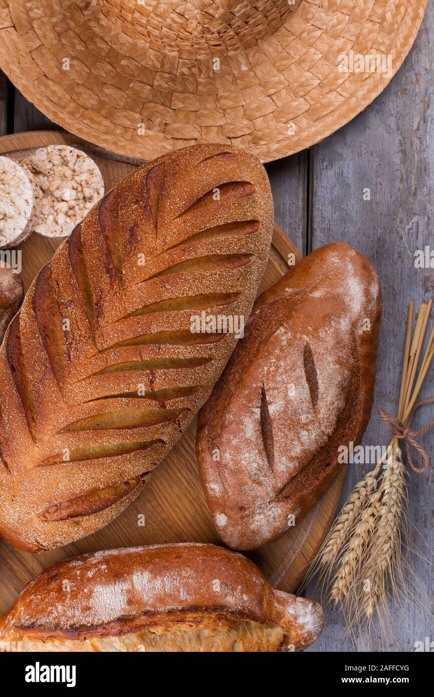 Bread and wheat ears on rustic table Stock Photo - Alamy