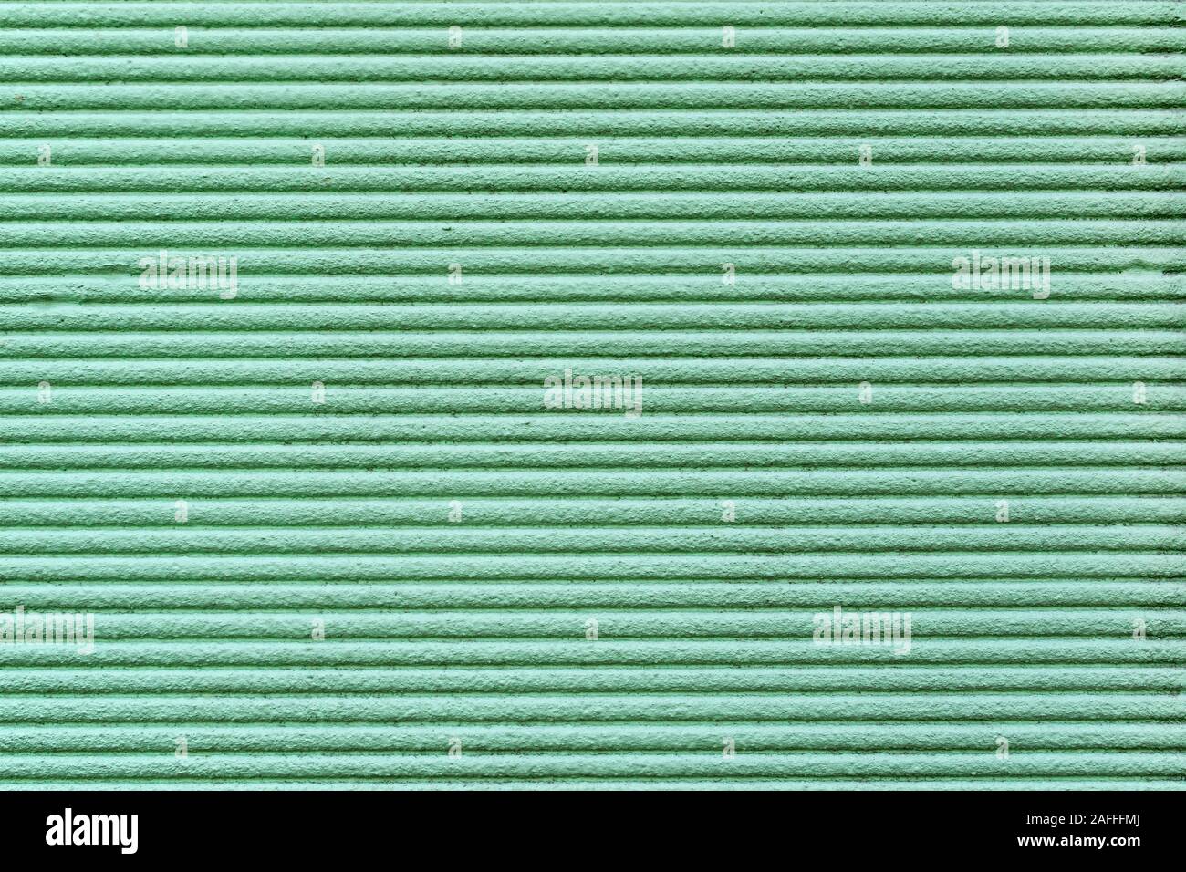Green relief striped stone wall. texture strip wall, surface