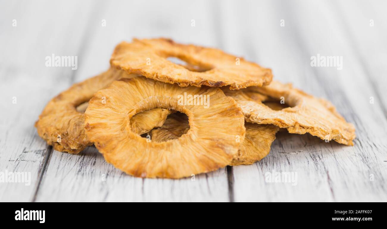 Pineapple rings (dried) on rustic wooden background as close-up shot Stock Photo