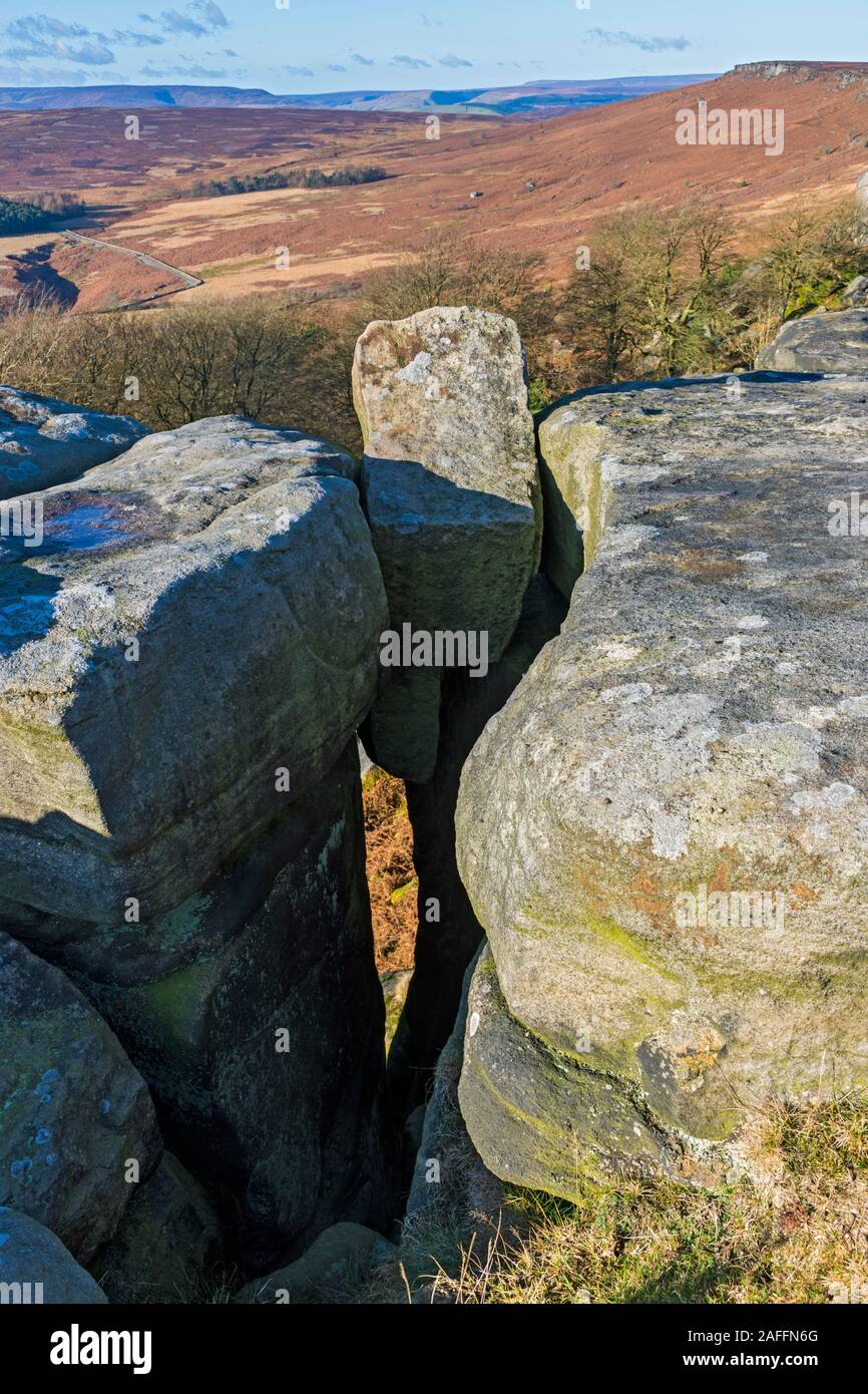 A chockstone wedged in a Millstone Grit outcrop on Stanage Edge, near Hathersage, Peak District, Derbyshire, England, UK. Stock Photo