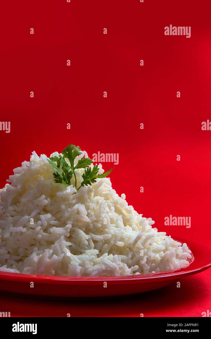 Cooked plain white basmati rice in a red plate on red background Stock Photo