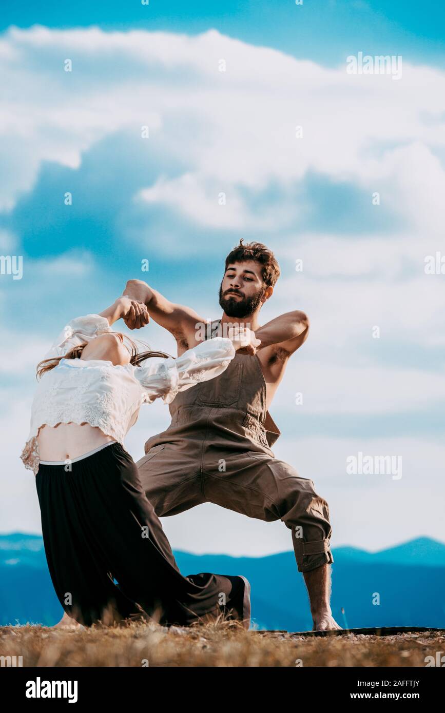 Two athletic young dancers making a performance at mountain peak Stock Photo