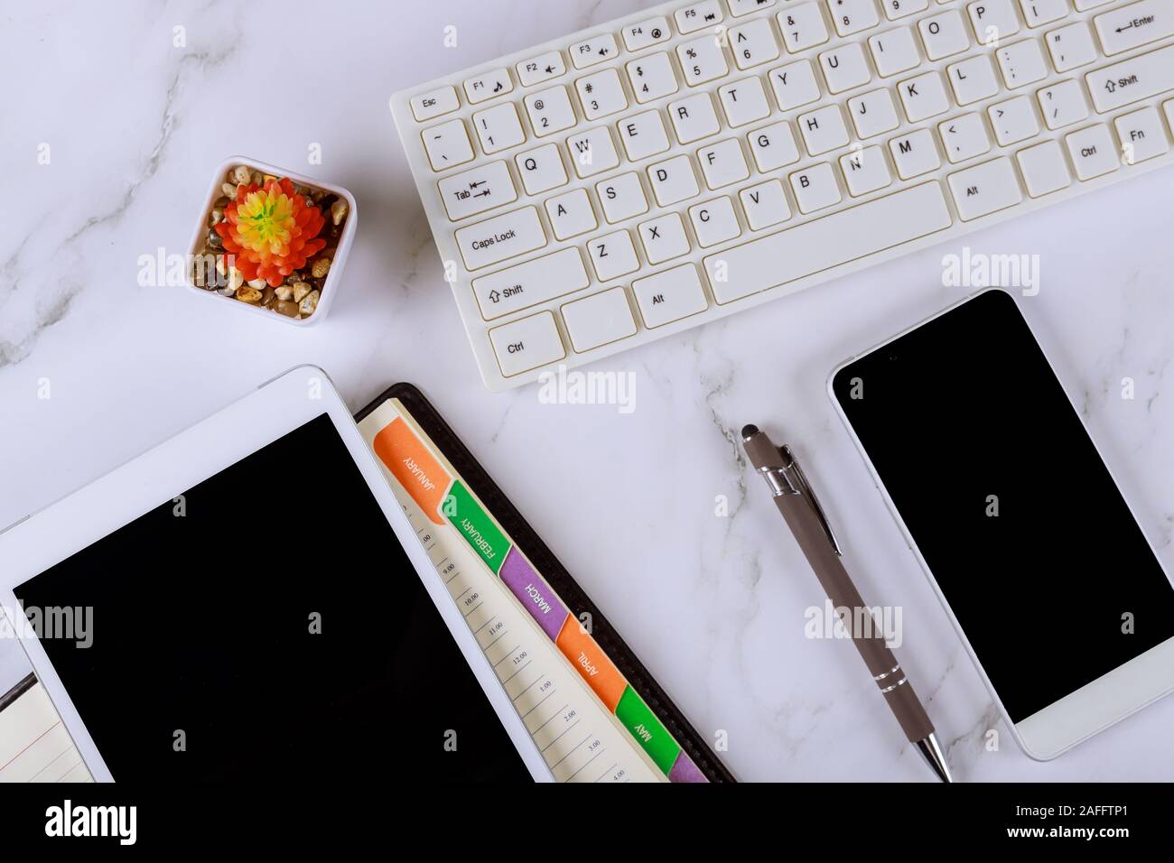 Workplace with composition pen, weekly notebook, mobile phone, digital tablet and computer keyboard Stock Photo