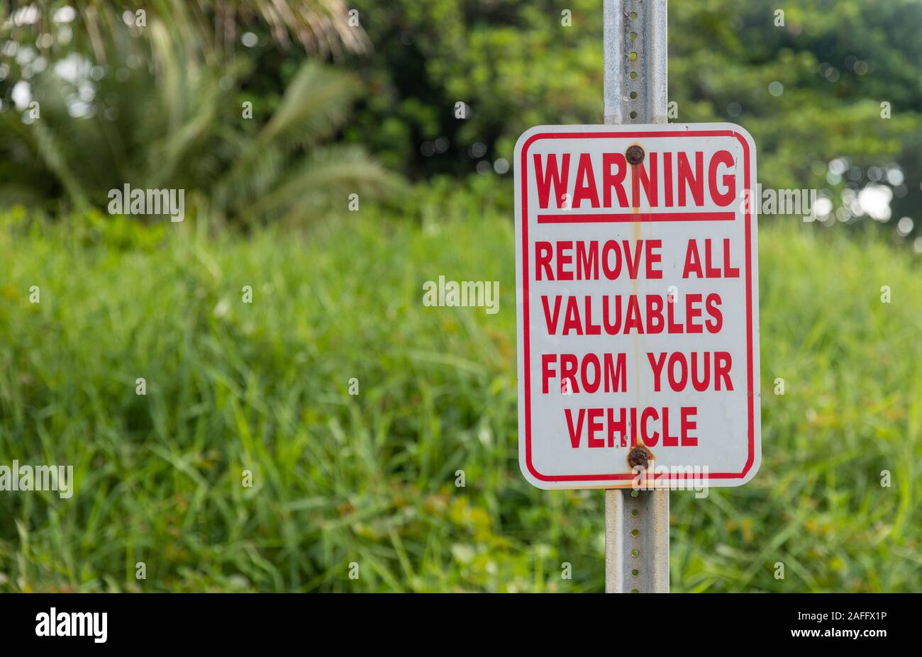 A sign warning about car vandalism in Hawaii Stock Photo