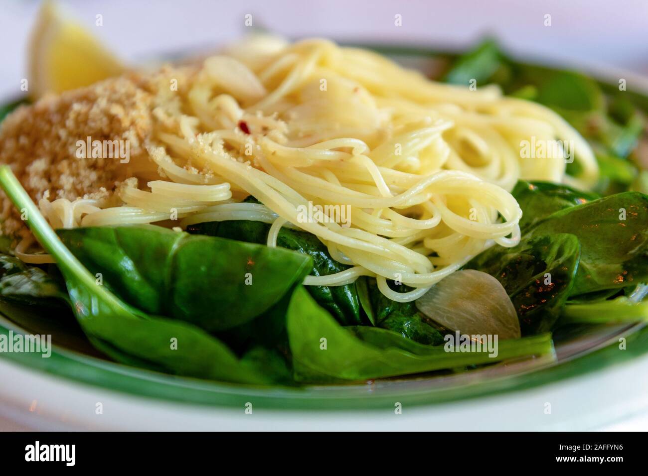 Closeup on capellini angel hair pasta with virgin olive oil, spinach