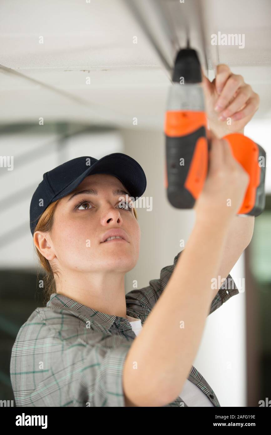 woman installing blinds with screwdriver Stock Photo
