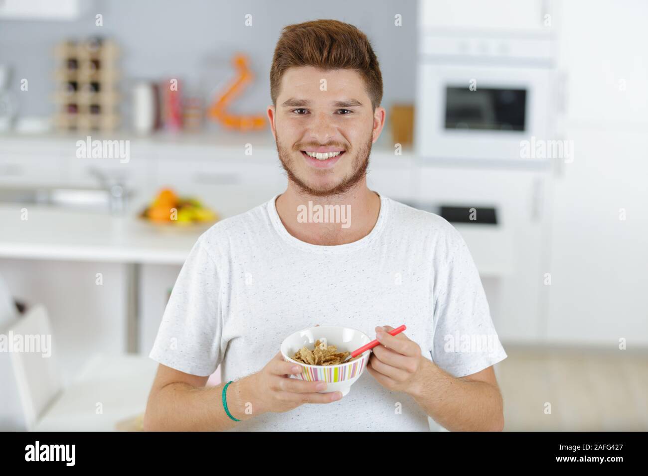 portrait of a teenage boy eating breakfast cereal Stock Photo