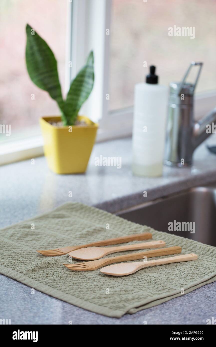 Re-usable bamboo cutlery drying on a kitchen towel in a kitchen. Stock Photo