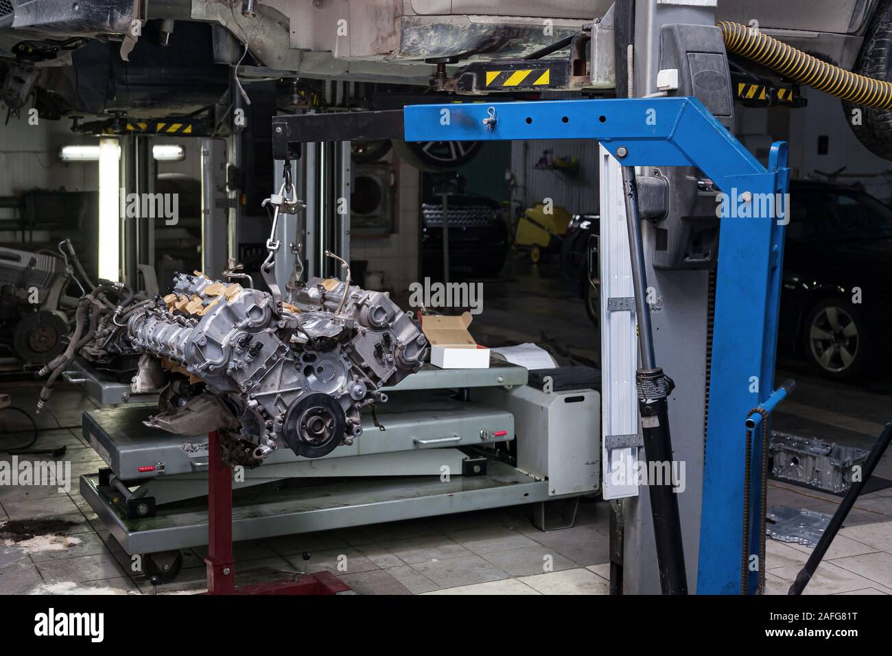 Used v8 engine with eight cylinders suspended mounted on a crane for