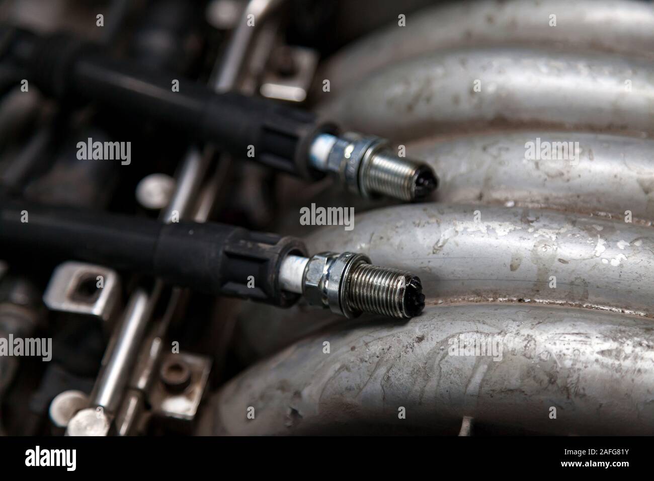 Spark plugs with high voltage wires on the engine under the hood of a