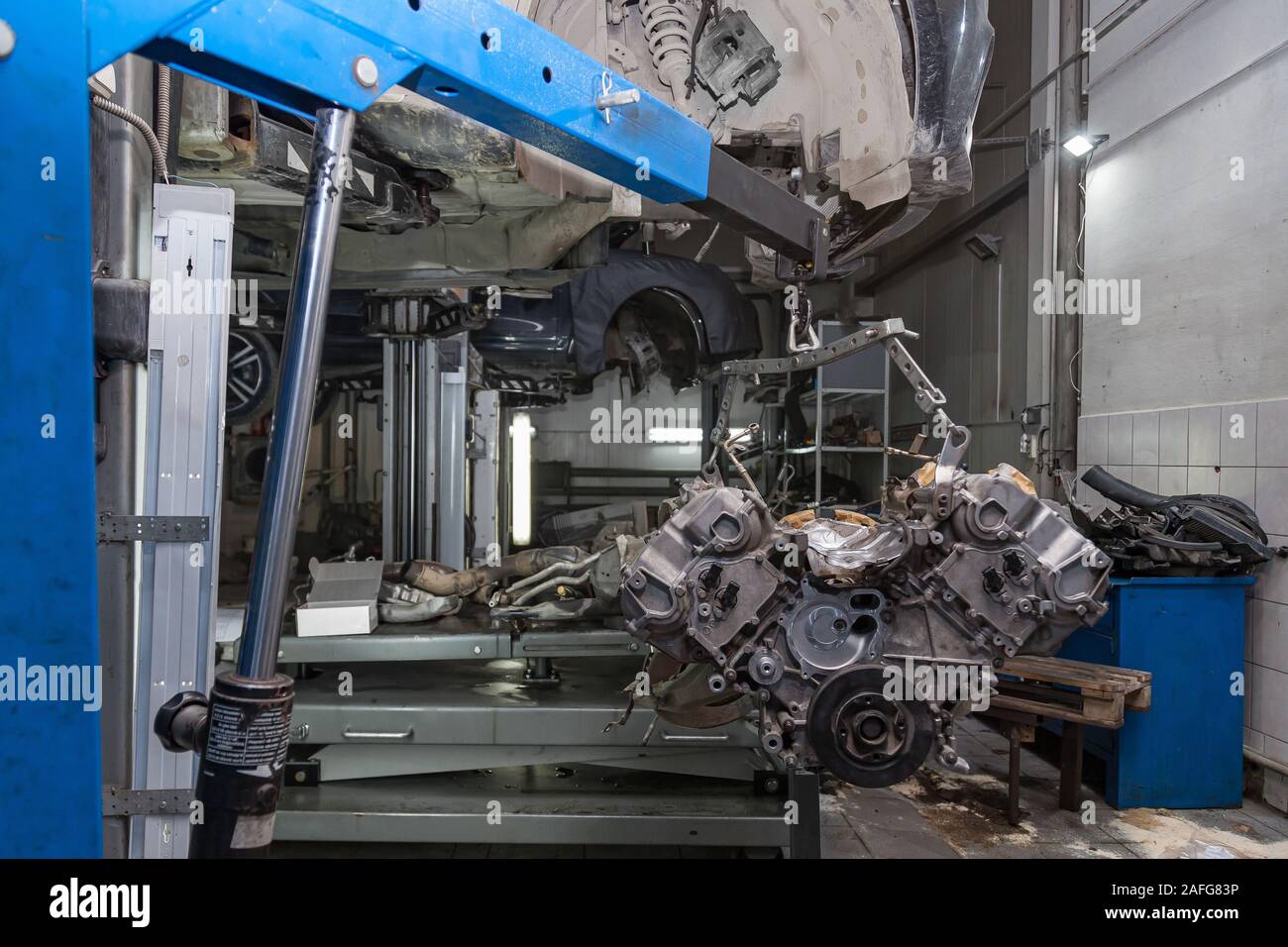 Used v8 engine with eight cylinders suspended mounted on a crane for