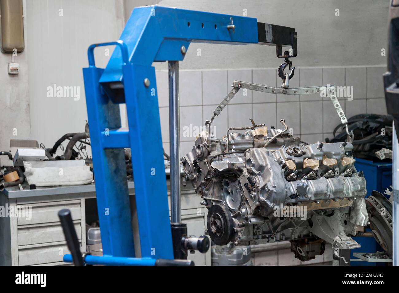 Used v8 engine with eight cylinders suspended mounted on a crane for