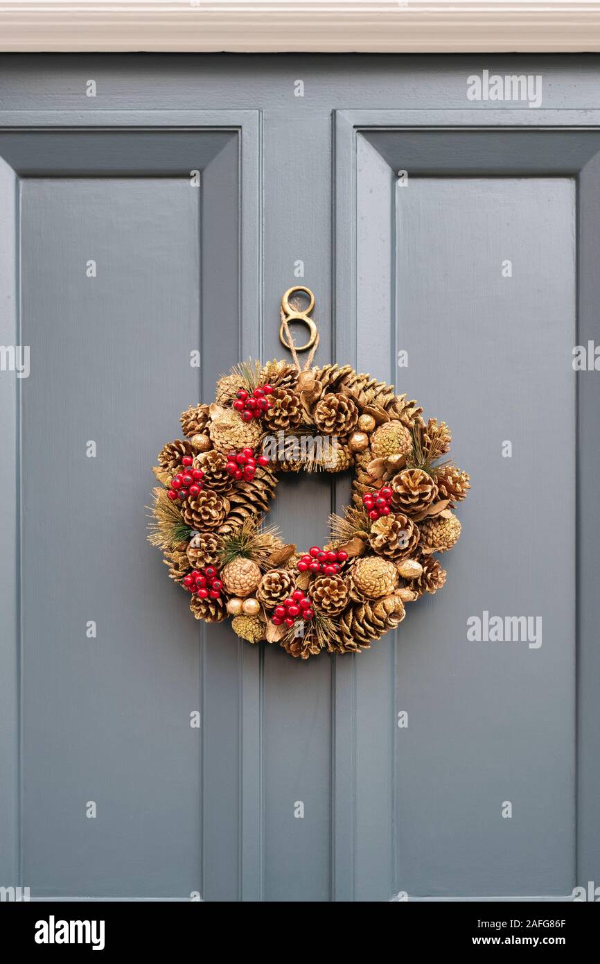 Gold coloured christmas wreath on a grey door. London, England Stock Photo