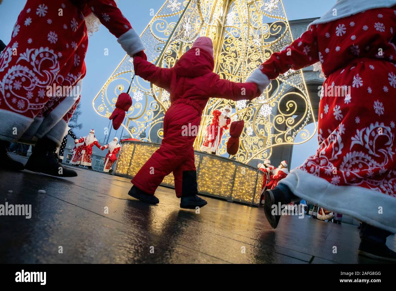 Moscow, Russia. 15th of December, 2019 People in Father Frost costumes lead a round dance  around the Christmas tree during the Father Frosts Festival at VDNKh in Moscow, Russia Stock Photo