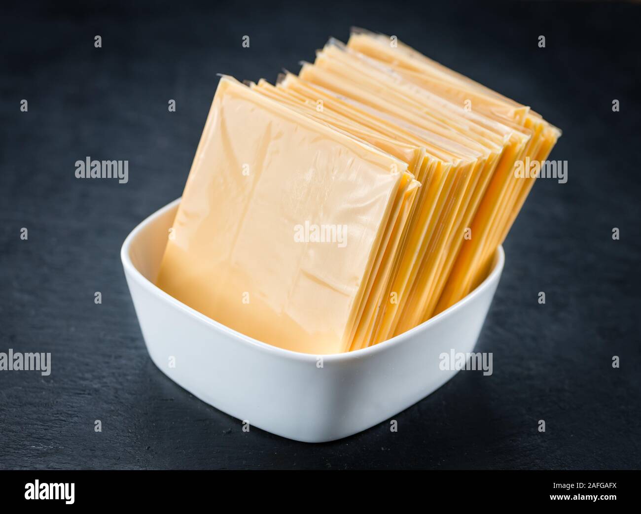 Portion of Cheese slices on a rustic slate slab (selective focus; close-up shot) Stock Photo
