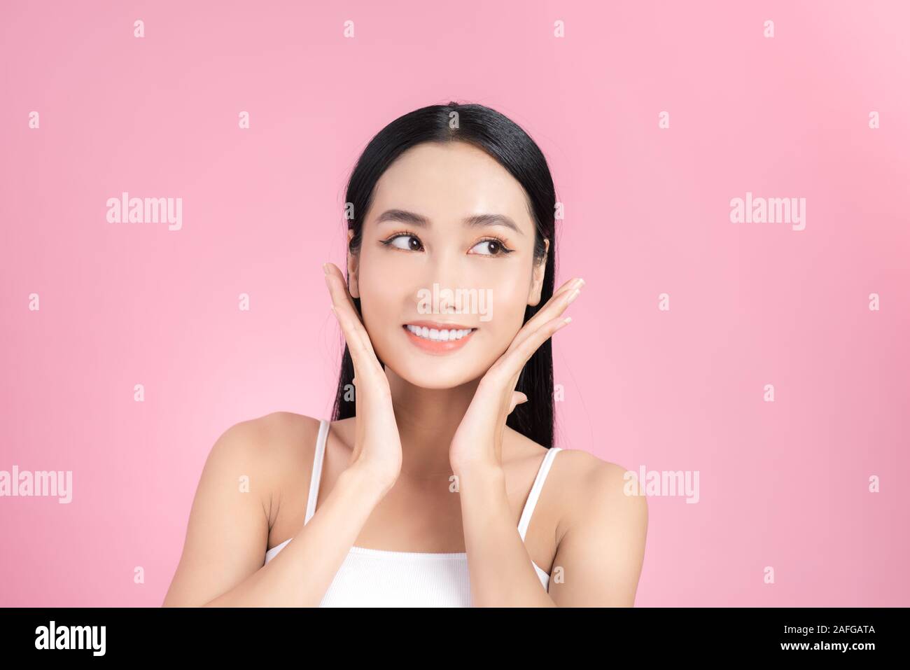 Beautiful Asian Girl touching her face and smiling, pampering her skin ...