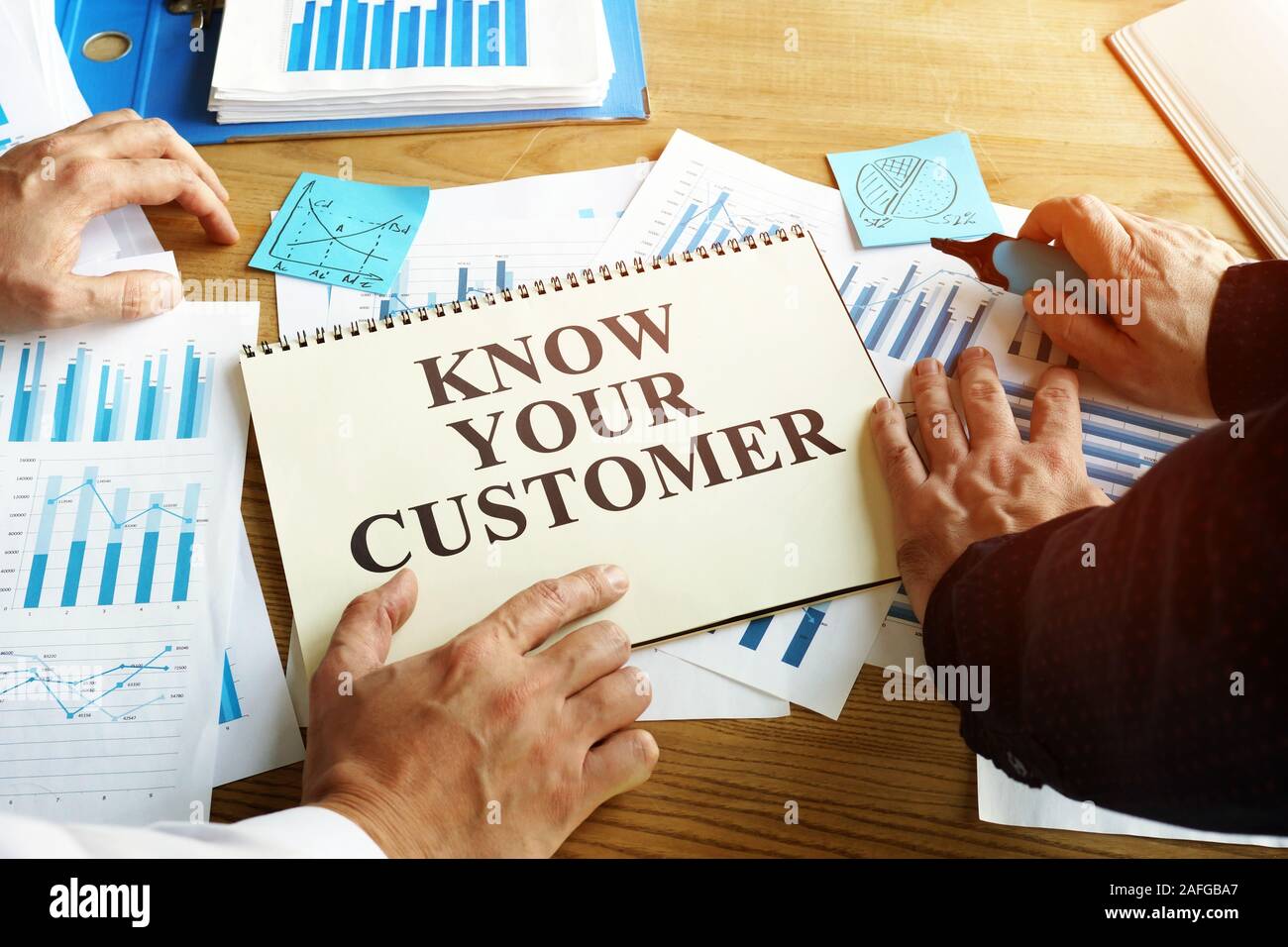 Know your customer sign. Businessmen read marketing report. Stock Photo