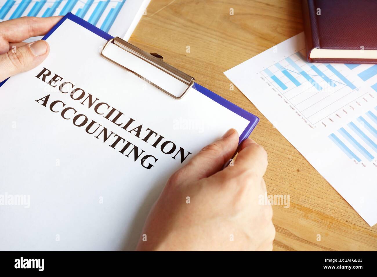 Reconciliation accounting papers in the accountant hand. Stock Photo