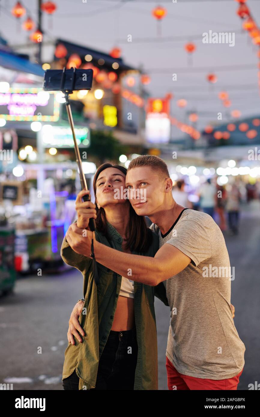 Happy young couple in love taking selfie on smartphone when walking at ...