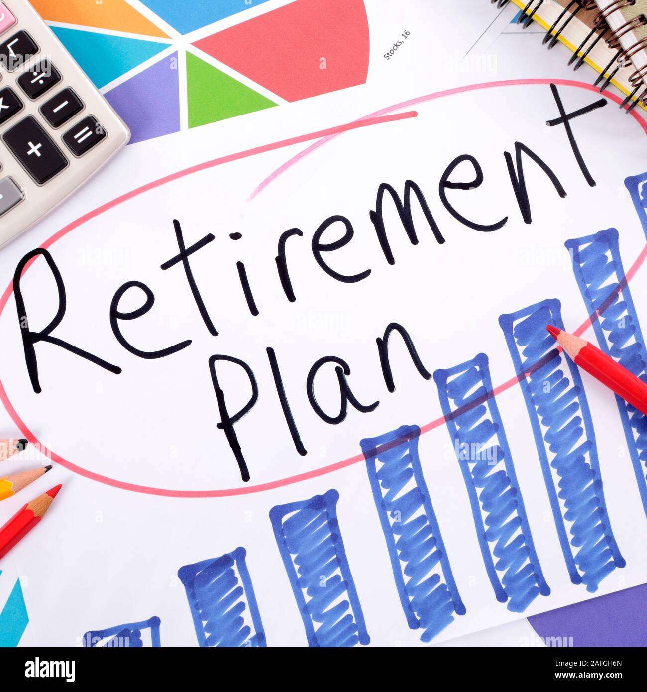 The words Retirement Plan written on a hand drawn bar chart surrounded by pencils, books and calculator. Stock Photo