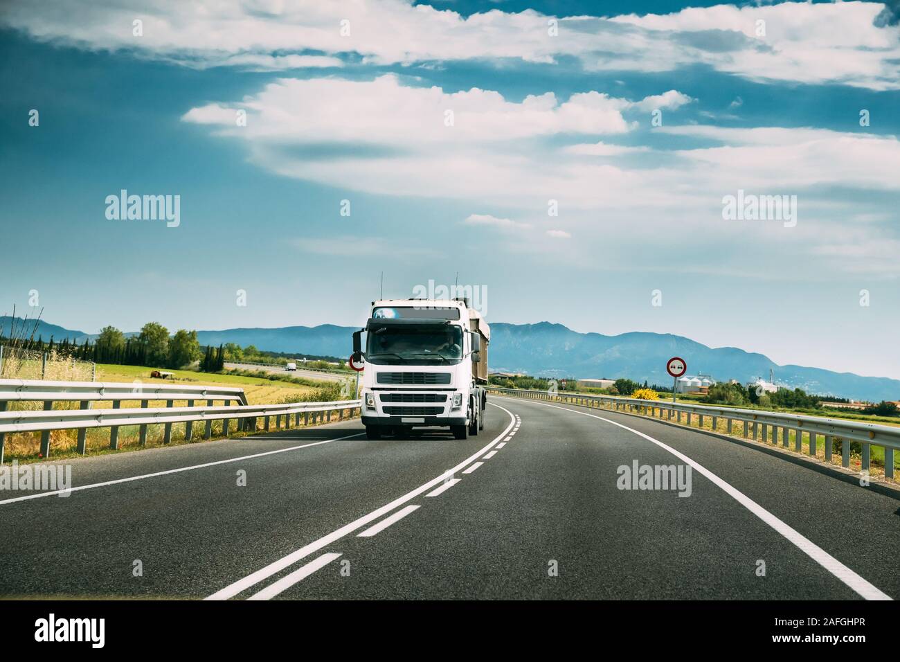 White Truck Or Traction Unit In Motion On Road, Freeway. Asphalt Motorway Highway Against Background Of Mountains Landscape. Business Transportation A Stock Photo