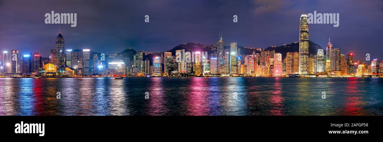 Panorama of high-rise waterfront buildings illuminated at night. Hong Kong, China. Stock Photo