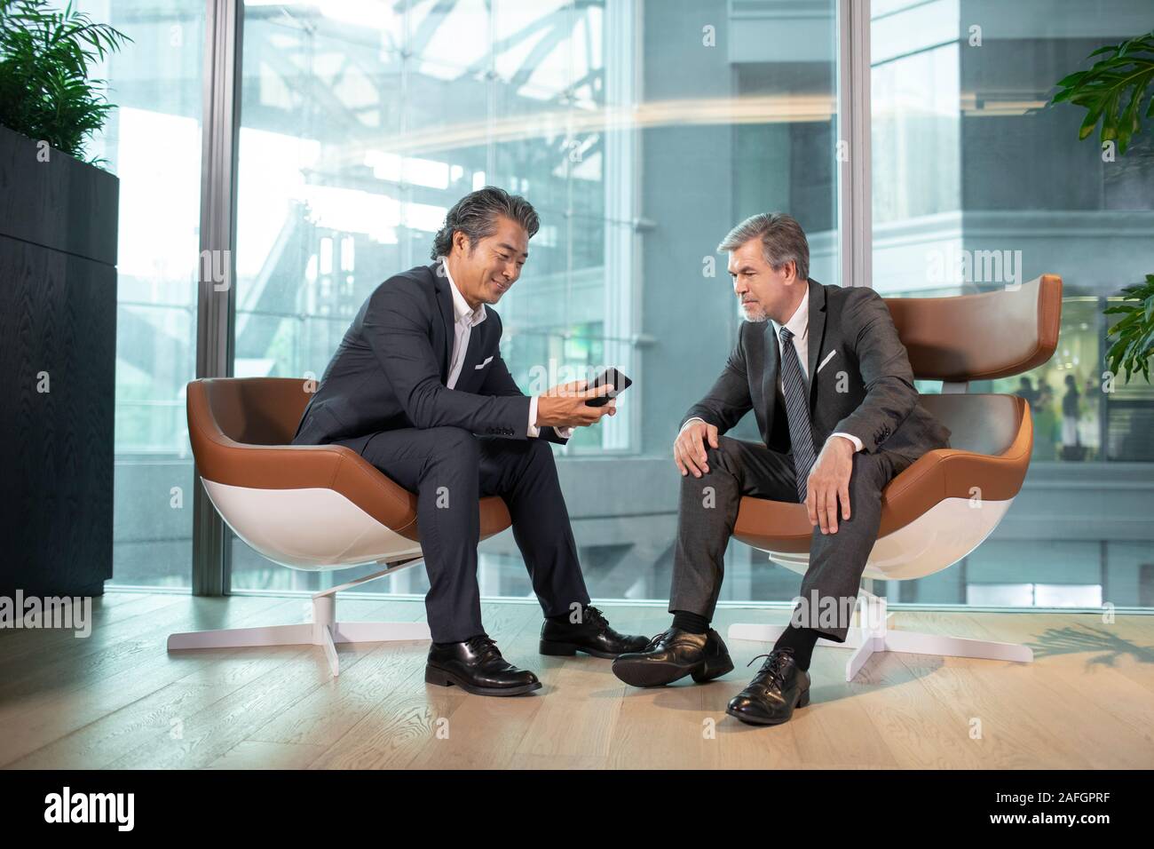 Businessmen using smartphone in office Stock Photo
