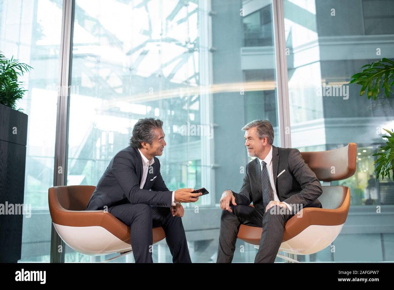 Businessmen using smartphone in office Stock Photo