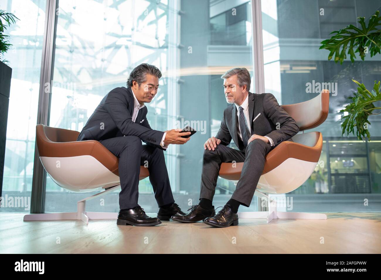 Businessmen using smartphone in office Stock Photo