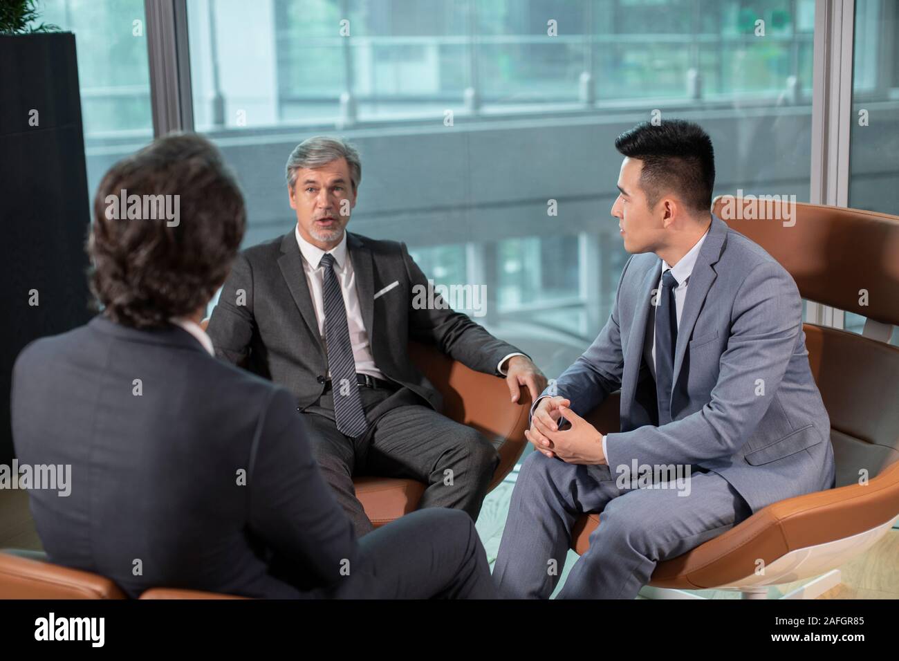 Businessmen talking in office Stock Photo