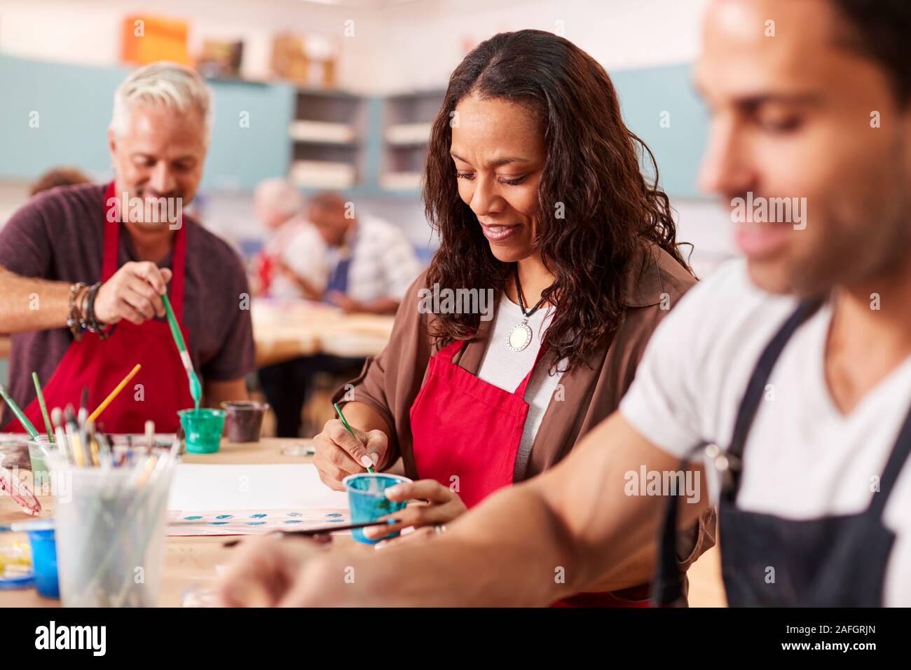 Group Of Mature Adults Attending Art Class In Community Centre Stock Photo