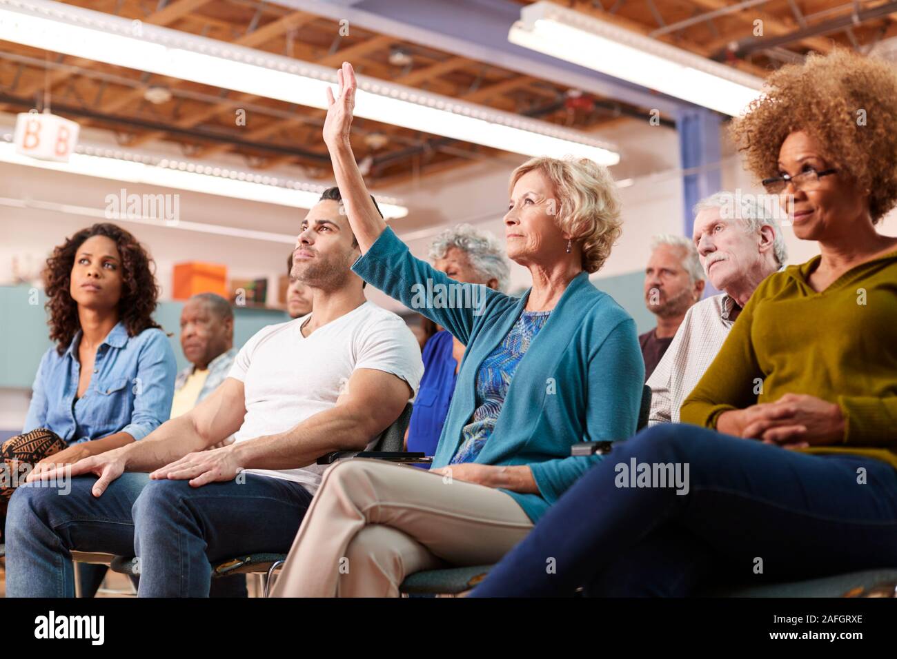 Woman Asking Question At Neighborhood Meeting In Community Center Stock Photo