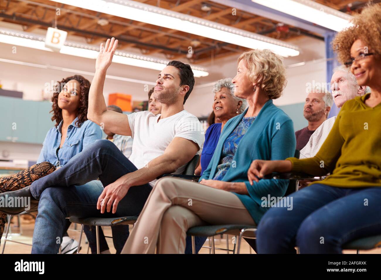 Man Asking Question At Neighborhood Meeting In Community Center Stock Photo