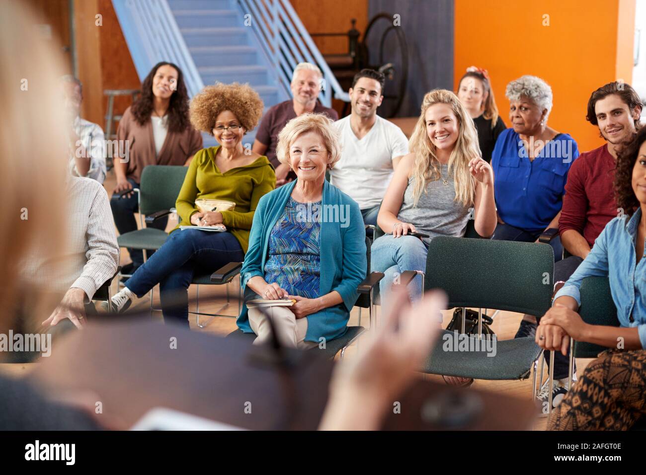 Group Attending Neighborhood Meeting Listening To Speaker In Community Center Stock Photo
