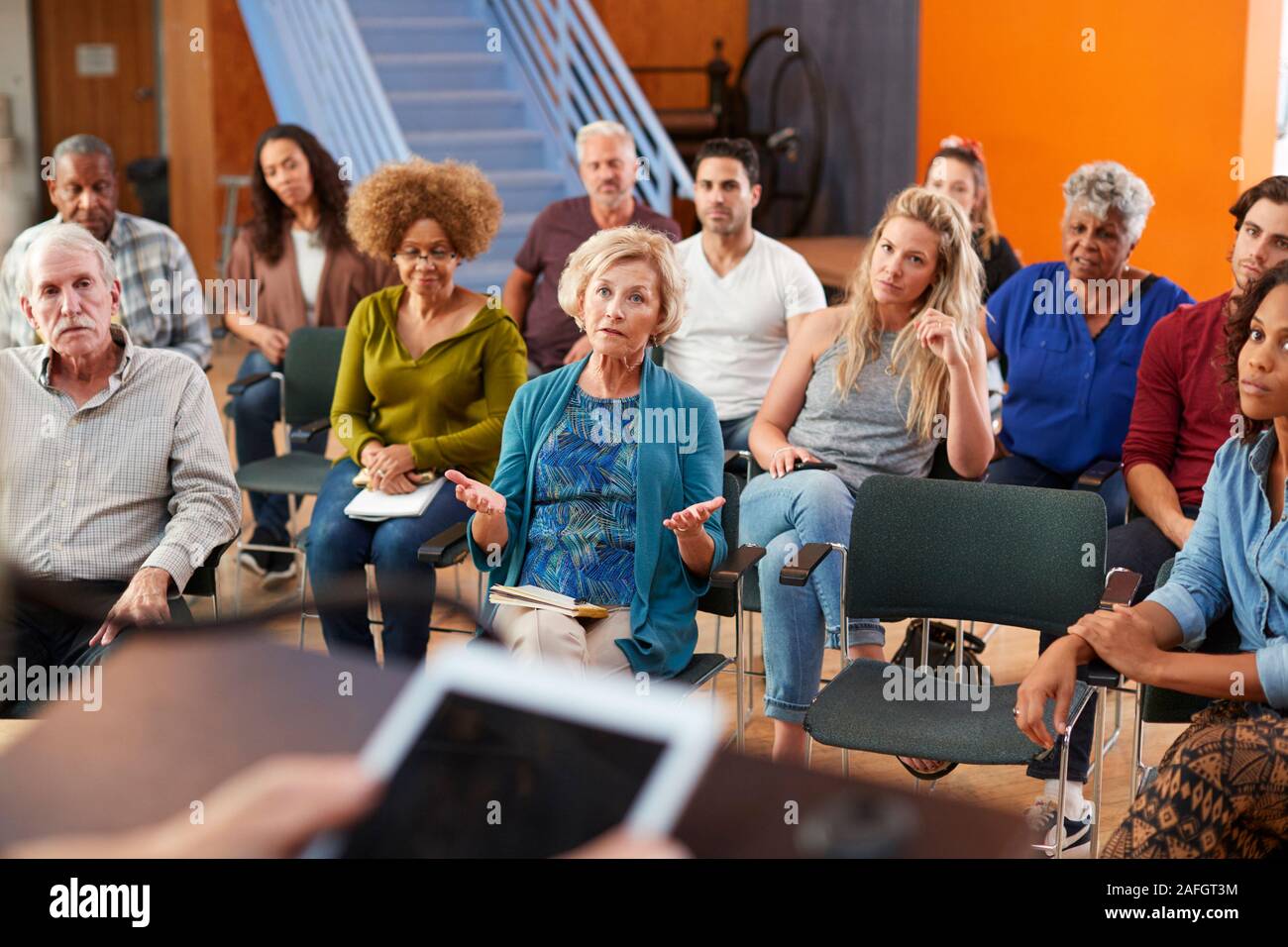 Woman Speaking At Group Neighborhood Meeting In Community Center Stock Photo