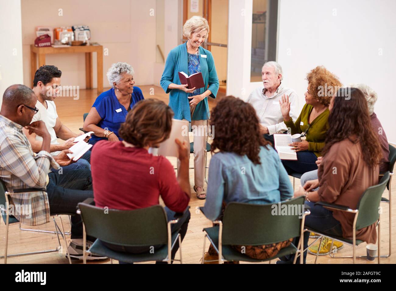 People Attending Bible Study Or Book Group Meeting In Community Center Stock Photo