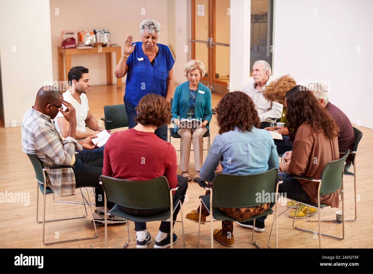 People Attending Bible Study Group Meeting In Community Center Stock Photo